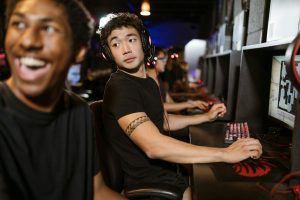 Người chơi e-sport theo dõi trận đấu và ghi chép kế hoạch quản lý vốn